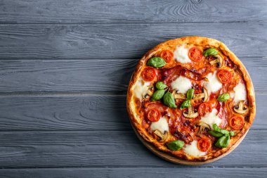 Lezzetli pizza üzerinde ahşap arka plan, üstten görünüm