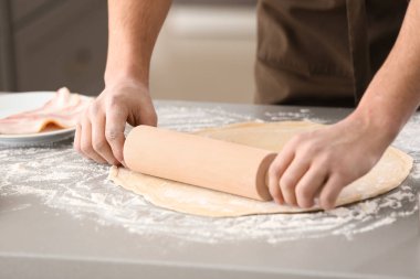 Genç adam masada pizza hamur hazırlama