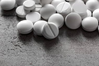 Gri dokulu arka plan üzerinde beyaz hap