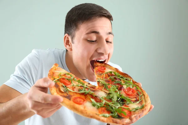 Jonge Man Lekker Pizza Eten Lichte Achtergrond — Stockfoto