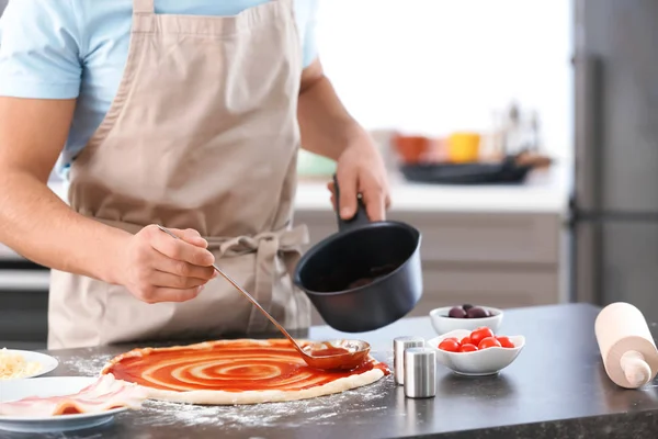 Mladý Muž Použití Omáčka Těsto Pizzu Stolu — Stock fotografie