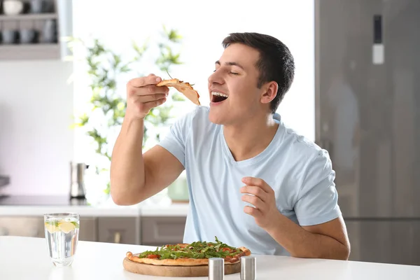 Молодой Человек Ест Вкусную Пиццу Дома — стоковое фото