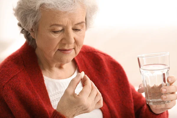 Elderly Woman Taking Pill Light Background — Stock Photo, Image