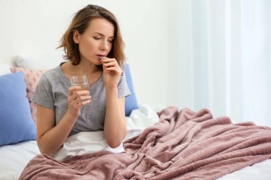 Genç kadın alarak hap yatakta