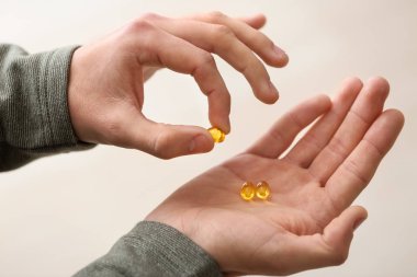 Açık renkli, closeup hapları tutan genç adam