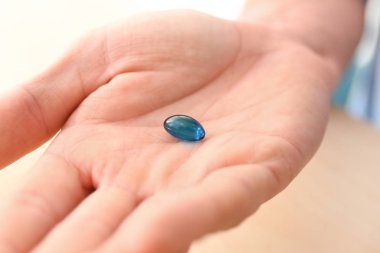 Genç adam mavi hap, closeup holding