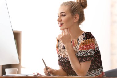 Güzel genç tasarımcı ofiste çalışıyor.