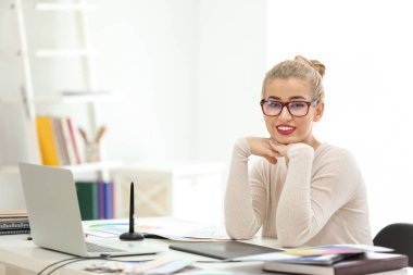 Güzel genç tasarımcı ofiste çalışıyor.