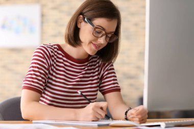 Güzel genç tasarımcı ofiste çalışıyor.