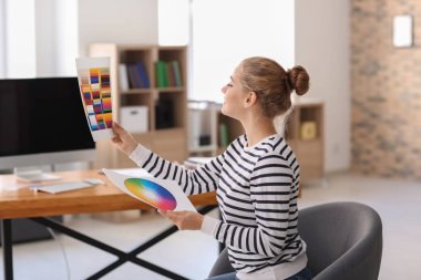 Güzel genç tasarımcı ofiste çalışıyor.