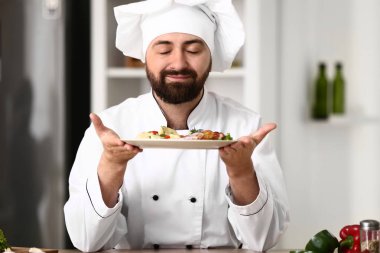 Mutfakta lezzetli yemekleri olan erkek aşçı.
