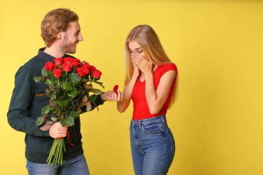 Genç adam onun sevgili renk arka plan üzerinde için teklif