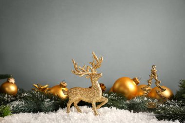 Altın Ren geyiği ile gri arka plan üzerinde Noel süsleri