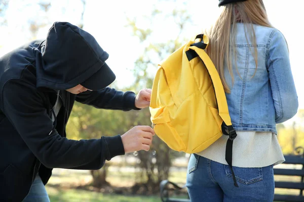 试图从公园里的年轻女子那里偷钱的男子小偷 — 图库照片