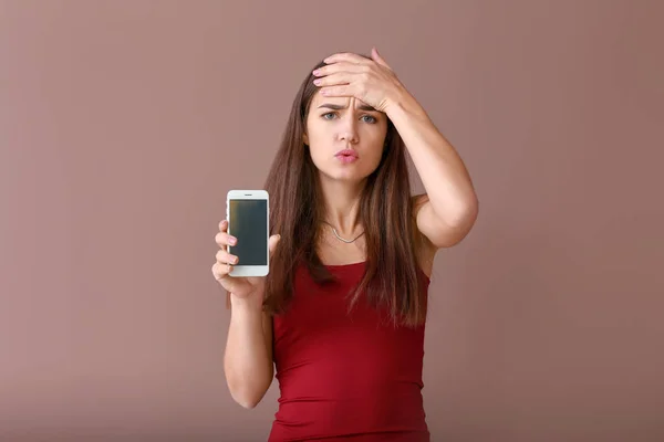 Mujer Joven Estresada Con Teléfono Móvil Funcional Sobre Fondo Color —  Fotos de Stock