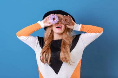 Lezzetli donuts renk arka plan üzerinde olan güzel kadın