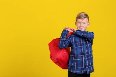 Renk arka plan üzerinde sırt çantası ile şirin küçük öğrenci