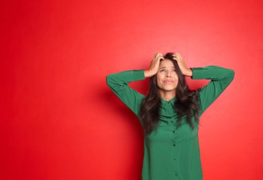 Renkli arka planda stresli genç bir kadın