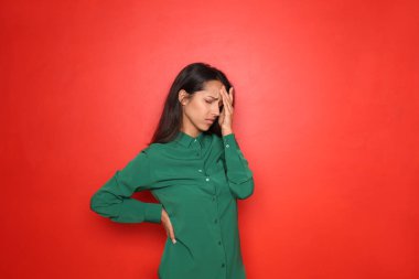 Renkli arka planda stresli genç bir kadın