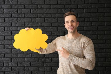 Karanlık tuğla zemin üzerine konuşma balonu ile genç adam