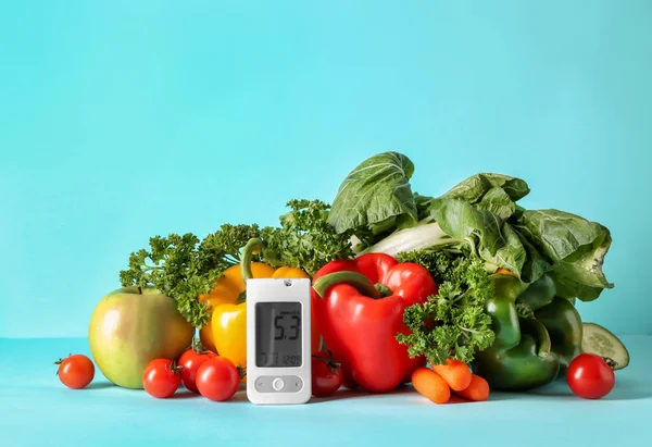 Digital glucometer with healthy food on color background. Diabetes diet