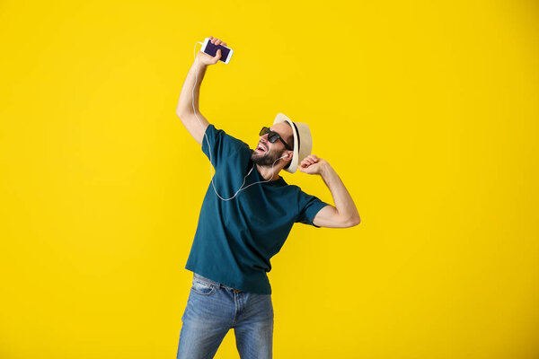 Красивый молодой человек танцует на цветном фоне
