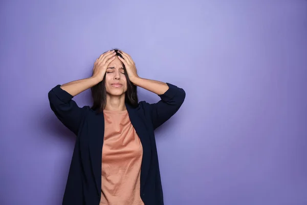 Stressed young woman on color background