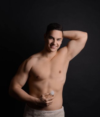 Koyu arka plan deodorant ile genç adam