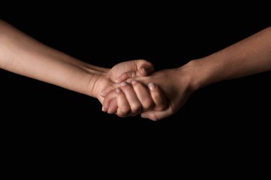 Koyu arka plan üzerinde el ele tutuşarak kadınlar