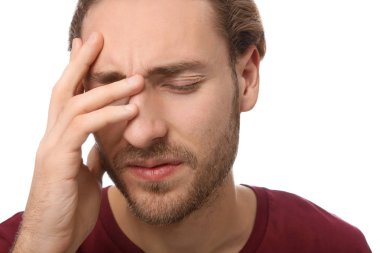 Genç adam beyaz arka planda, closeup baş ağrısı muzdarip