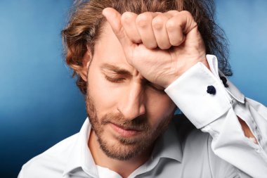 Arka planda baş ağrısı çeken genç bir adam