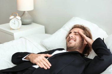 Genç işadamı yatak odasında baş ağrısı muzdarip