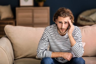 Genç adam evde baş ağrısı çekiyor.