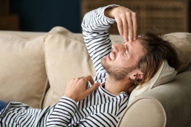 Genç adam evde baş ağrısı çekiyor.