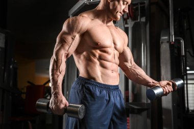 kaslı adam spor salonunda dumbbells ile eğitim