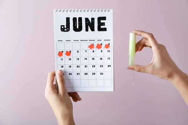 Frau Mit Menstruationskalender Und Tampon Auf Farbigem Hintergrund — Stockfoto
