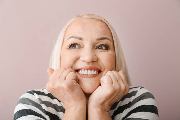 Портрет возбужденной зрелой женщины на цветном фоне
