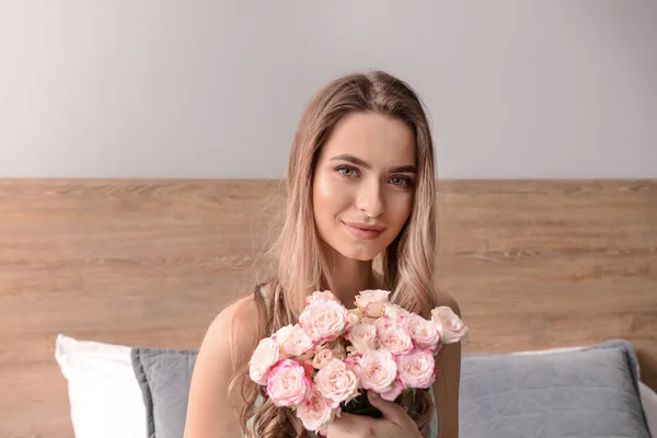 自宅で花の花束を持つ美しい若い女性 — ストック写真