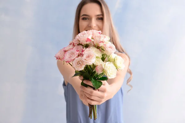 色の背景上の花の花束と美しい若い女性 — ストック写真