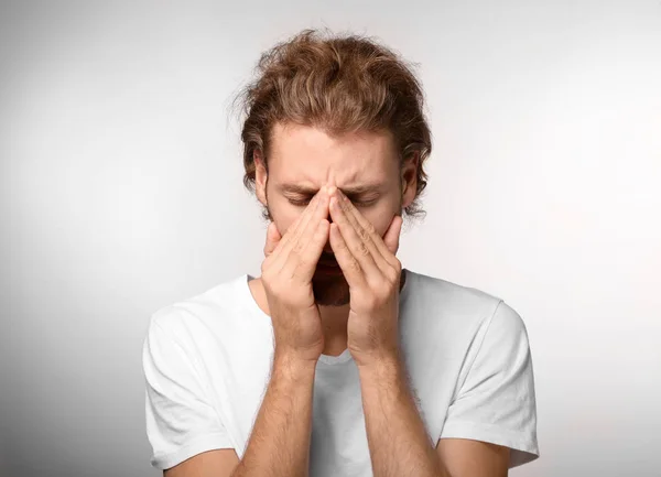 Young Man Suffering Headache Light Background — Stock Photo, Image