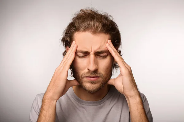 Young Man Suffering Headache Light Background — Stock Photo, Image