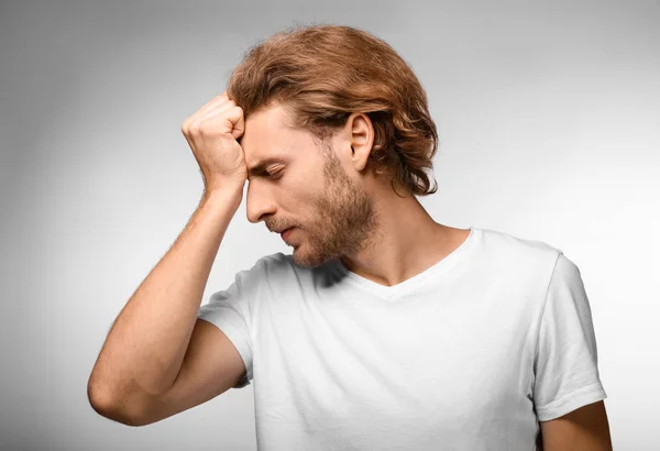 Young Man Suffering Headache Light Background — Stock Photo, Image