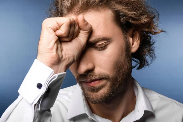 Arka planda baş ağrısı çeken genç bir adam