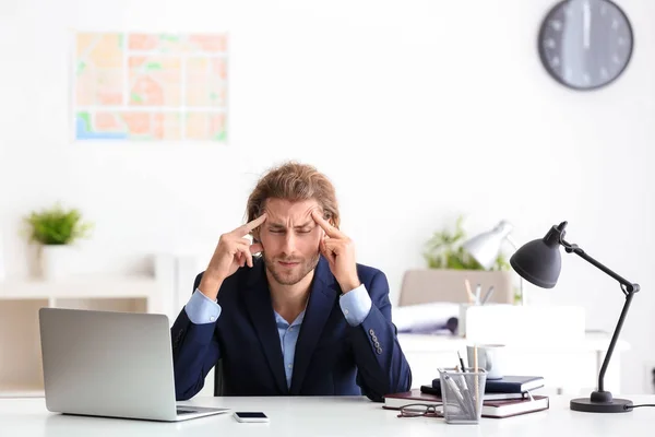 オフィスで頭痛に苦しんでいる青年実業家 — ストック写真