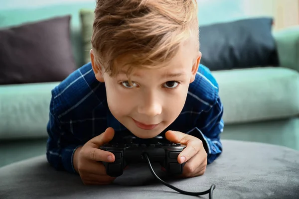 Cute boy playing video game at home