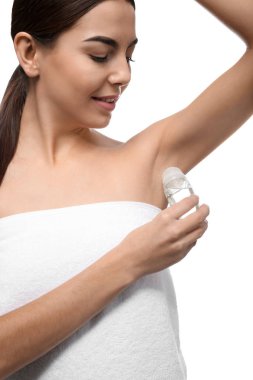 Beyaz arka plan üzerinde deodorant kullanan genç kadın