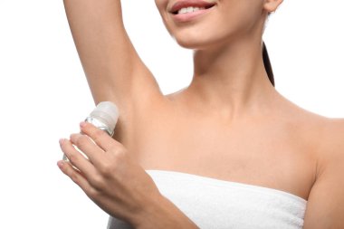 Beyaz arka plan üzerinde deodorant kullanan genç kadın