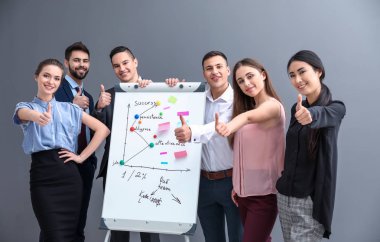 Flipchart gri arka plan üzerinde yakın genç kişilik ekibin