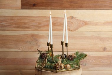 Noel dekor ahşap duvar yakınındaki masada ile yanan mumlar