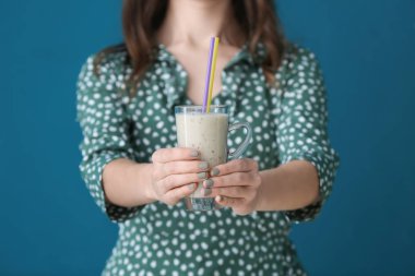 Cam fincan lezzetli smoothie renk arka plan üzerinde kadınla